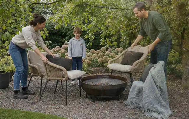 Familie stellt wetterfeste Sessel an einem geschützten Sitzplatz im Garten auf; Thema Poolfilter, Schwerpunkt Systemvergleich; Ausgangslage.