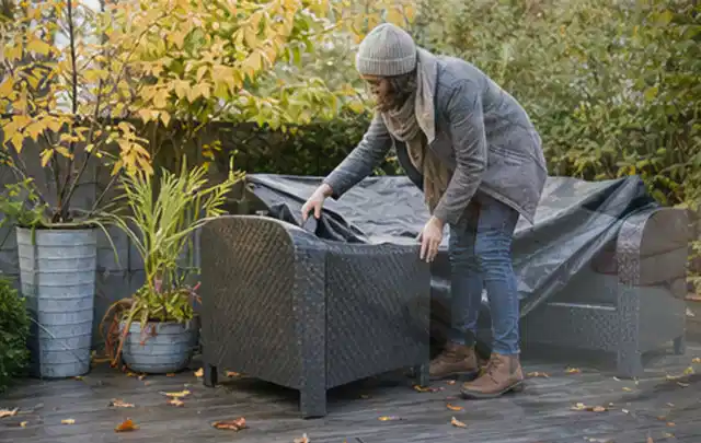 Person deckt Gartenmöbel vor der kalten Jahreszeit sorgfältig ab; Thema Poolheizungen, Schwerpunkt Vergleich; Ergebnis.