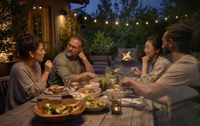 Menschen verbringen einen ruhigen Abend an einem Sitzplatz im Garten; Thema Poolpflege, Schwerpunkt Anwendung; Praxisalltag.