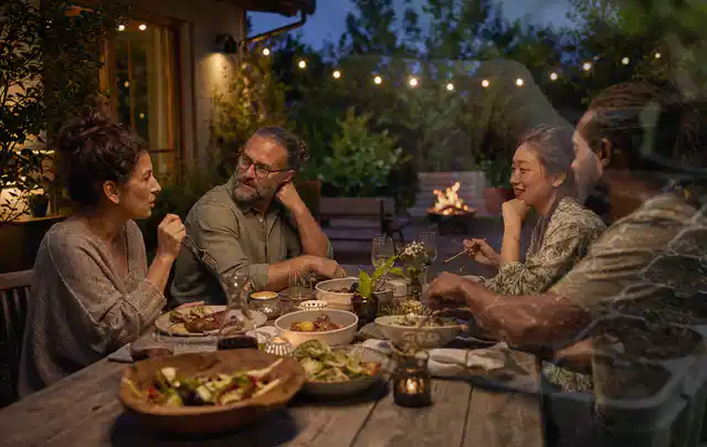 Menschen verbringen einen ruhigen Abend an einem Sitzplatz im Garten; Thema Poolpflege, Schwerpunkt Winterlager; Ergebnis.