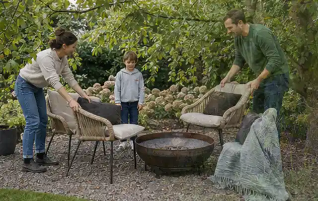 Familie stellt wetterfeste Sessel an einem geschützten Sitzplatz im Garten auf; Thema Poolpumpen, Schwerpunkt Kaufberatung; Praxisalltag.