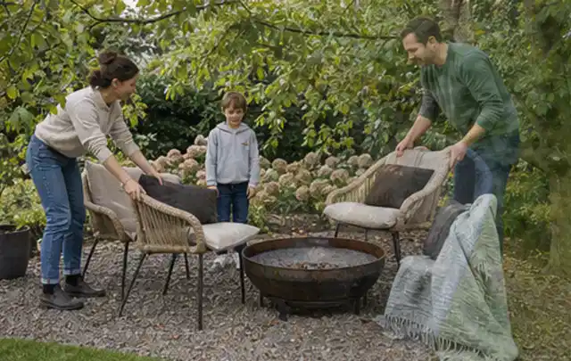 Familie stellt wetterfeste Sessel an einem geschützten Sitzplatz im Garten auf; Thema Poolpumpen, Schwerpunkt Reparatur; Praxisalltag.