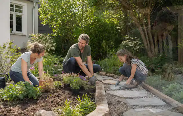 Familie geht auf einem Weg durch einen abwechslungsreich gestalteten Garten; Thema Rankpflanzen als Sichtschutz, Schwerpunkt Checkliste; Praxisalltag.