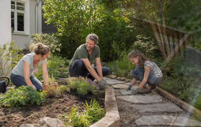 Familie geht auf einem Weg durch einen abwechslungsreich gestalteten Garten; Thema Rankpflanzen als Sichtschutz, Schwerpunkt Dimensionierung; Kontrolle.