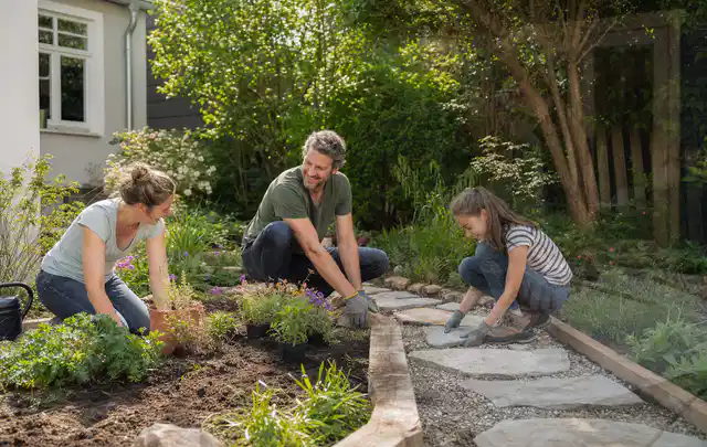 Familie geht auf einem Weg durch einen abwechslungsreich gestalteten Garten; Thema Rankpflanzen als Sichtschutz, Schwerpunkt DIY; Ergebnis.
