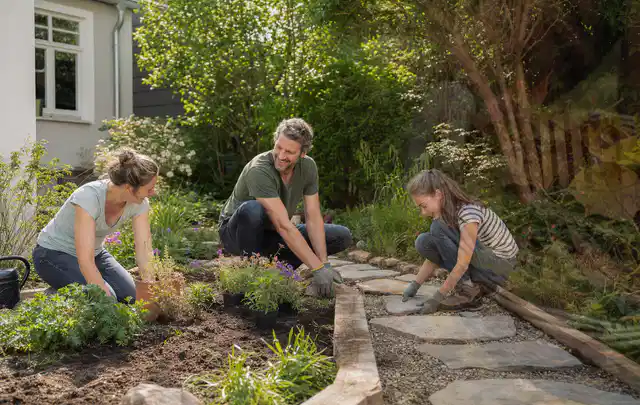 Familie geht auf einem Weg durch einen abwechslungsreich gestalteten Garten; Thema Rankpflanzen als Sichtschutz, Schwerpunkt Fehlerhilfe; Praxisalltag.