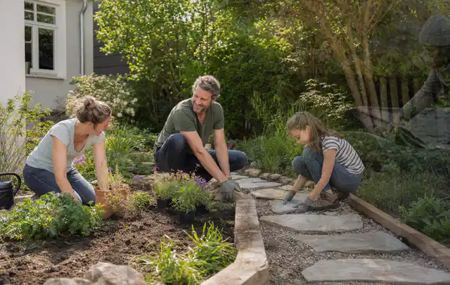 Familie geht auf einem Weg durch einen abwechslungsreich gestalteten Garten; Thema Rankpflanzen als Sichtschutz, Schwerpunkt Gestaltung; Praxisalltag.