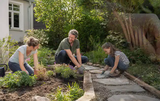 Familie geht auf einem Weg durch einen abwechslungsreich gestalteten Garten; Thema Rankpflanzen als Sichtschutz, Schwerpunkt Planung; Ausgangslage.