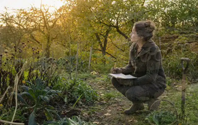 Person plant saisonale Gartenarbeiten mit Notizen an einem Gartentisch; Thema Ratgeber, Schwerpunkt Themenwelt; Ergebnis.