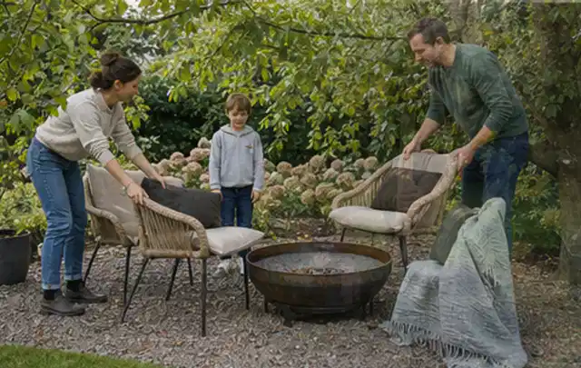 Familie stellt wetterfeste Sessel an einem geschützten Sitzplatz im Garten auf; Thema Salzwasserpools, Schwerpunkt Gärten mit großer Fläche; Praxisalltag.