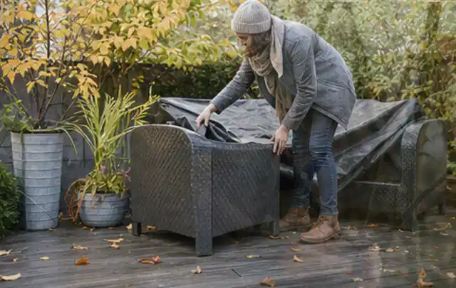 Person deckt Gartenmöbel vor der kalten Jahreszeit sorgfältig ab; Thema Sandfilteranlagen, Schwerpunkt Kosten; Umsetzung.