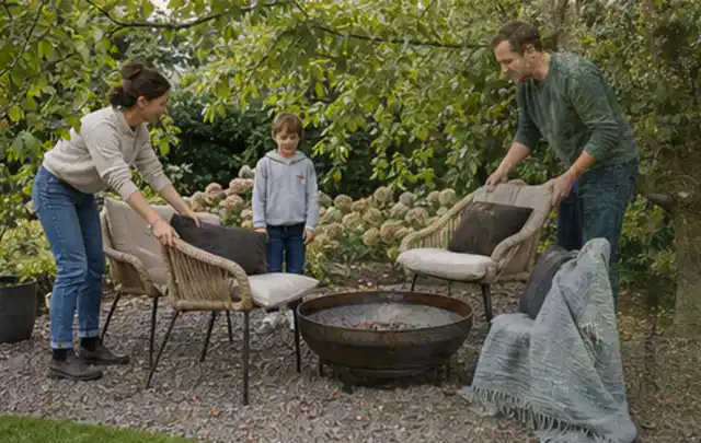 Familie stellt wetterfeste Sessel an einem geschützten Sitzplatz im Garten auf; Thema Sandfilteranlagen, Schwerpunkt Reparatur; Praxisalltag.