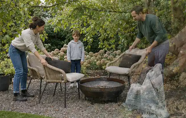 Familie stellt wetterfeste Sessel an einem geschützten Sitzplatz im Garten auf; Thema Sichtschutz aus Holz, Schwerpunkt Gärten mit kleiner Fläche;…