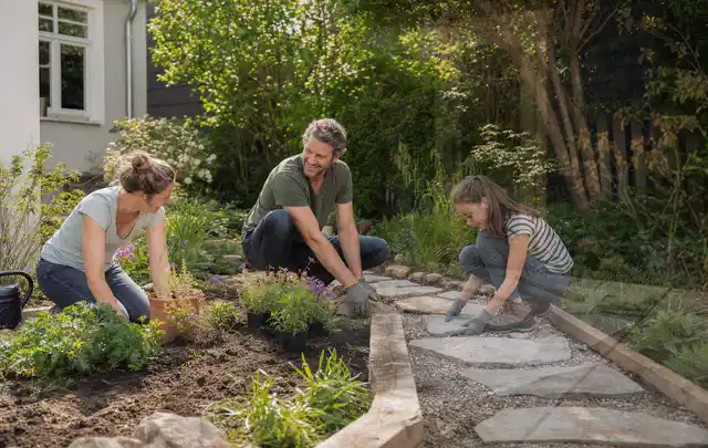 Familie geht auf einem Weg durch einen abwechslungsreich gestalteten Garten; Thema Sichtschutz, Schwerpunkt Themenwelt; Ergebnis.