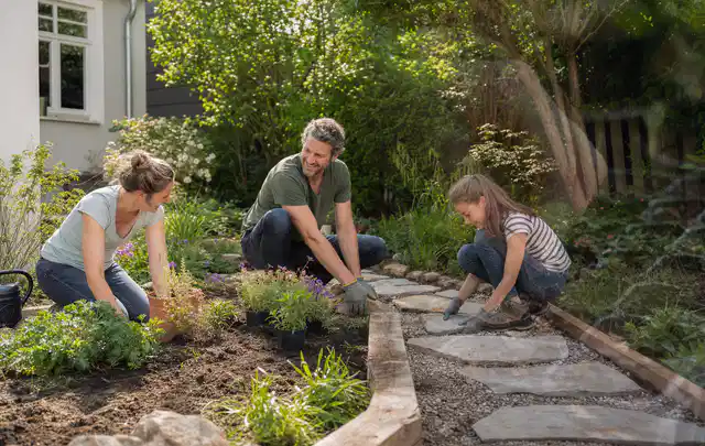 Familie geht auf einem Weg durch einen abwechslungsreich gestalteten Garten; Thema Sichtschutzhecken, Schwerpunkt Fehlerhilfe; Ergebnis.