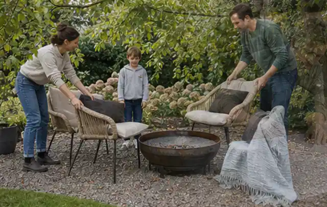 Familie stellt wetterfeste Sessel an einem geschützten Sitzplatz im Garten auf; Thema Sichtschutzhecken, Schwerpunkt Fundament; Umsetzung.