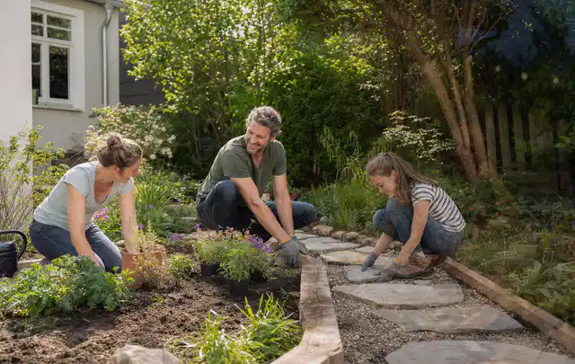 Familie geht auf einem Weg durch einen abwechslungsreich gestalteten Garten; Thema Sichtschutzhecken, Schwerpunkt Gestaltung; Kontrolle.