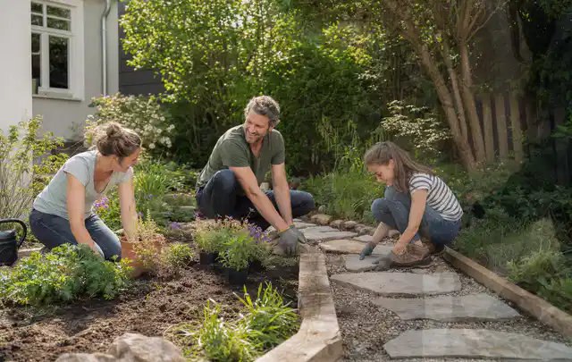Familie geht auf einem Weg durch einen abwechslungsreich gestalteten Garten; Thema Sichtschutzhecken, Schwerpunkt Materialwahl; Ergebnis.