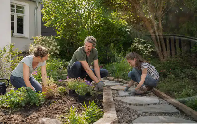 Familie geht auf einem Weg durch einen abwechslungsreich gestalteten Garten; Thema Sichtschutzhecken, Schwerpunkt Pflege; Kontrolle.