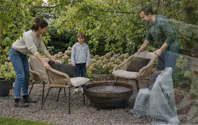 Familie stellt wetterfeste Sessel an einem geschützten Sitzplatz im Garten auf; Thema Smoker, Schwerpunkt Ersatzteile; Praxisalltag.
