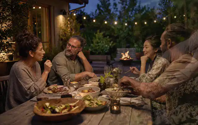 Menschen verbringen einen ruhigen Abend an einem Sitzplatz im Garten; Thema Smoker, Schwerpunkt Gärten mit großer Fläche; Ausgangslage.