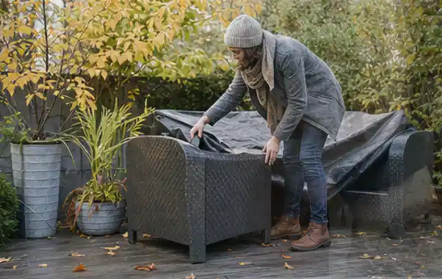 Person deckt Gartenmöbel vor der kalten Jahreszeit sorgfältig ab; Thema Smoker, Schwerpunkt Kosten; Ergebnis.