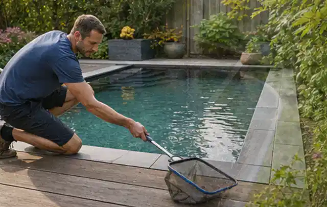 Person entfernt Blätter mit einem Kescher aus einem kleinen Gartenpool; Thema Smoker, Schwerpunkt Reparatur; Ausgangslage.