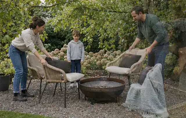 Familie stellt wetterfeste Sessel an einem geschützten Sitzplatz im Garten auf; Thema Smoker, Schwerpunkt Reparatur; Kontrolle.
