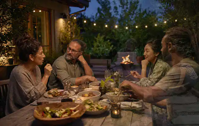 Menschen verbringen einen ruhigen Abend an einem Sitzplatz im Garten; Thema Smoker, Schwerpunkt Sicherheit; Praxisalltag.