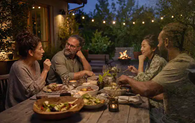 Menschen verbringen einen ruhigen Abend an einem Sitzplatz im Garten; Thema Smoker, Schwerpunkt Winterlager; Praxisalltag.