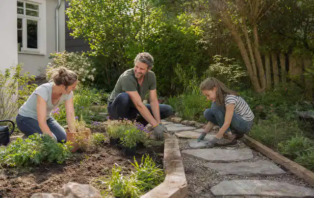 Familie geht auf einem Weg durch einen abwechslungsreich gestalteten Garten; Thema Steingarten, Schwerpunkt Beleuchtung; Kontrolle.