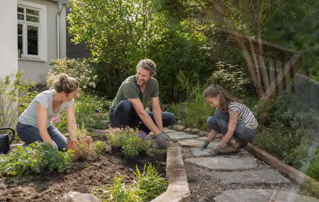 Familie geht auf einem Weg durch einen abwechslungsreich gestalteten Garten; Thema Steingarten, Schwerpunkt Garten gestalten; Umsetzung.