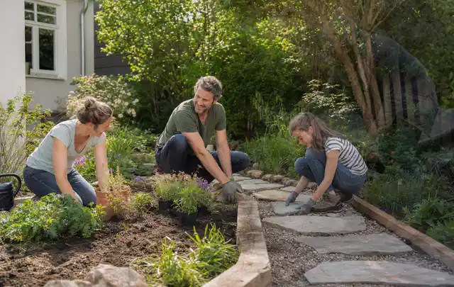 Familie geht auf einem Weg durch einen abwechslungsreich gestalteten Garten; Thema Steingarten, Schwerpunkt Naturgarten; Praxisalltag.