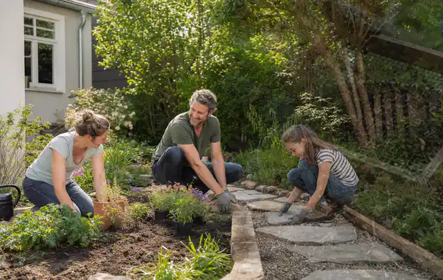 Familie geht auf einem Weg durch einen abwechslungsreich gestalteten Garten; Thema Steingarten, Schwerpunkt Planung; Ausgangslage.