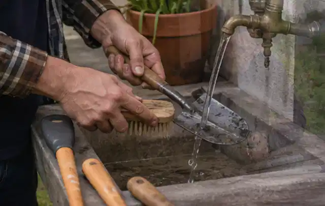Hände reinigen gebrauchte Gartengeräte mit Bürste und Wasser am Außenbecken; Thema Stihl iMow, Schwerpunkt Leistung; Umsetzung.