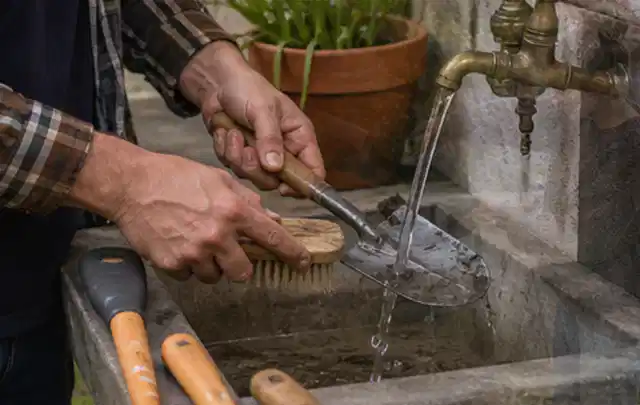 Hände reinigen gebrauchte Gartengeräte mit Bürste und Wasser am Außenbecken; Thema Stihl iMow, Schwerpunkt Systemvergleich; Kontrolle.