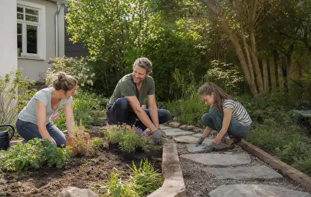 Familie geht auf einem Weg durch einen abwechslungsreich gestalteten Garten; Thema Terrasse, Schwerpunkt Anleitung; Umsetzung.