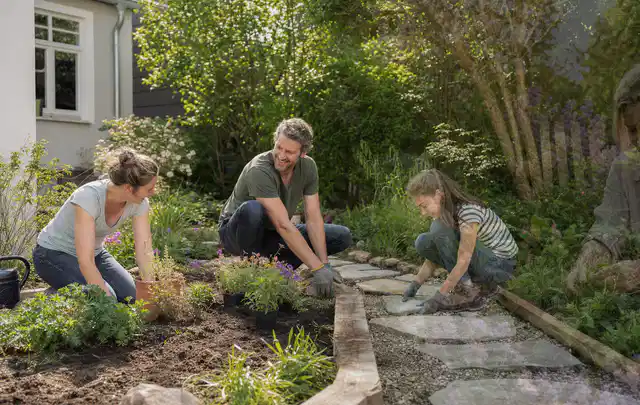 Familie geht auf einem Weg durch einen abwechslungsreich gestalteten Garten; Thema Terrasse, Schwerpunkt Fehlerhilfe; Kontrolle.