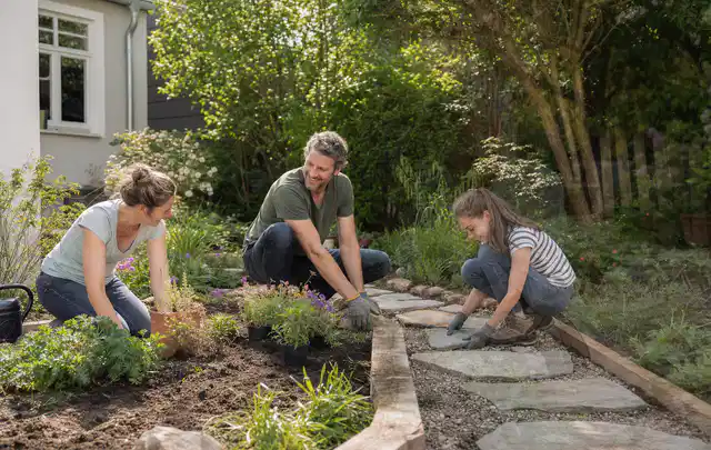 Familie geht auf einem Weg durch einen abwechslungsreich gestalteten Garten; Thema Terrasse, Schwerpunkt Gärten mit kleiner Fläche; Kontrolle.