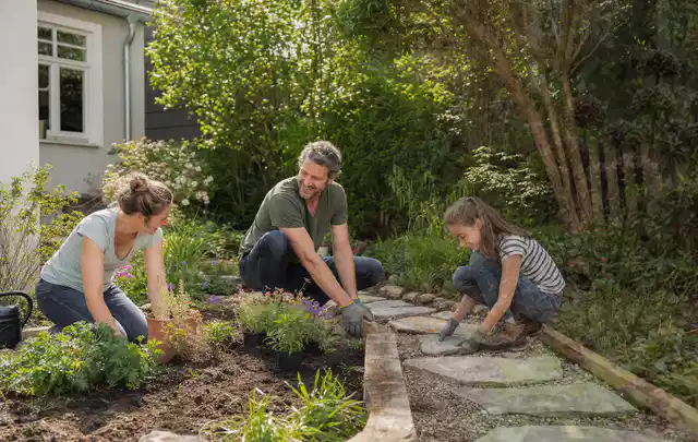 Familie geht auf einem Weg durch einen abwechslungsreich gestalteten Garten; Thema Terrasse, Schwerpunkt Kosten; Ergebnis.