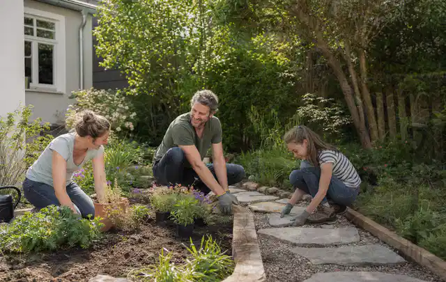 Familie geht auf einem Weg durch einen abwechslungsreich gestalteten Garten; Thema Terrasse, Schwerpunkt Pflegeleichtigkeit; Praxisalltag.