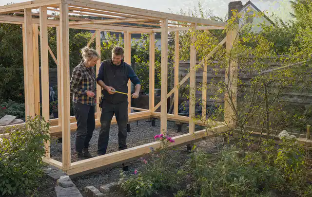 Person plant den Bau eines Gartenhauses auf einer vorbereiteten Fläche; Thema Terrassen, Schwerpunkt Gartenhäuser Bauen; Kontrolle.