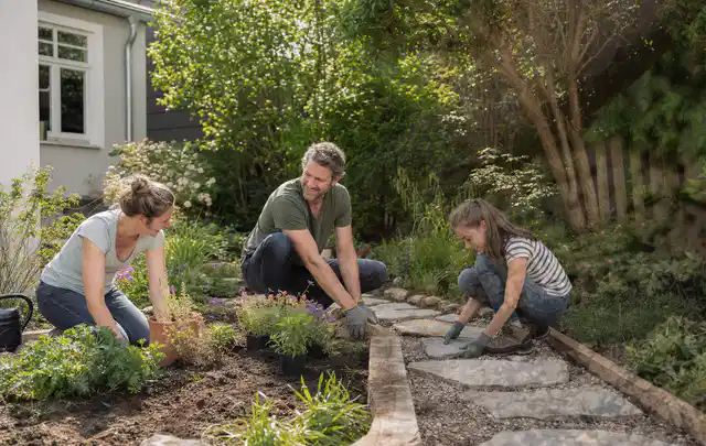 Familie geht auf einem Weg durch einen abwechslungsreich gestalteten Garten; Thema Vorgarten, Schwerpunkt Beleuchtung; Umsetzung.