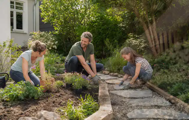 Familie geht auf einem Weg durch einen abwechslungsreich gestalteten Garten; Thema Vorgarten, Schwerpunkt Planung; Ergebnis.