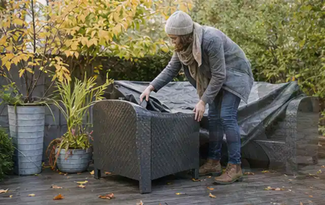 Person deckt Gartenmöbel vor der kalten Jahreszeit sorgfältig ab; Thema Whirlpools, Schwerpunkt Checkliste; Ausgangslage.