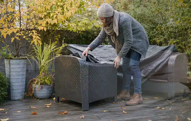 Person deckt Gartenmöbel vor der kalten Jahreszeit sorgfältig ab; Thema Whirlpools, Schwerpunkt Reinigung; Ergebnis.