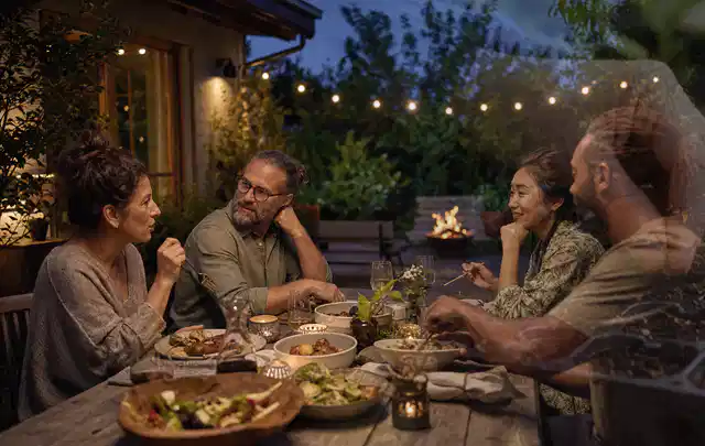 Menschen verbringen einen ruhigen Abend an einem Sitzplatz im Garten; Thema Whirlpools, Schwerpunkt Winterlager; Praxisalltag.