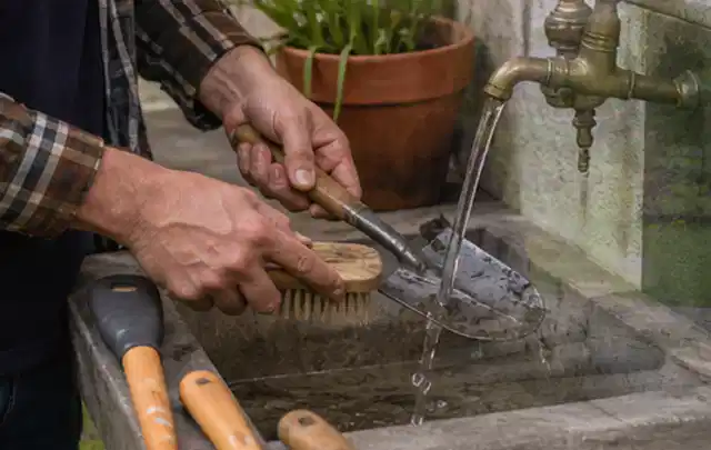 Hände reinigen gebrauchte Gartengeräte mit Bürste und Wasser am Außenbecken; Thema Worx Landroid, Schwerpunkt Dimensionierung; Umsetzung.