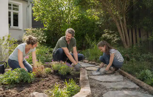 Familie geht auf einem Weg durch einen abwechslungsreich gestalteten Garten; Thema WPC Sichtschutz, Schwerpunkt Baurecht; Ergebnis.