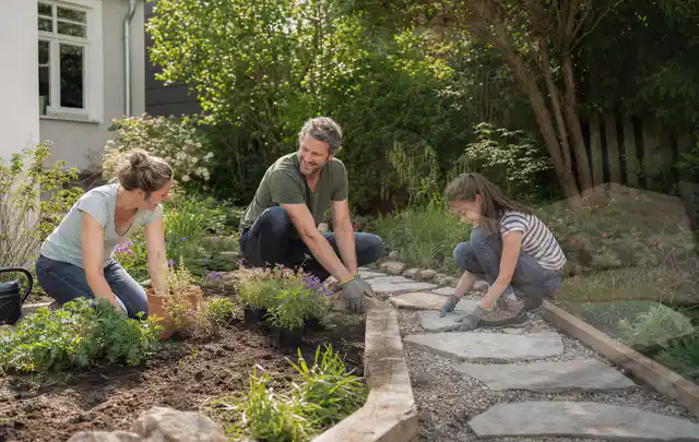 Familie geht auf einem Weg durch einen abwechslungsreich gestalteten Garten; Thema WPC Sichtschutz, Schwerpunkt Planung; Ausgangslage.
